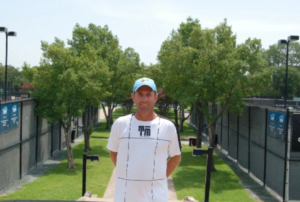 A man standing in front of some trees