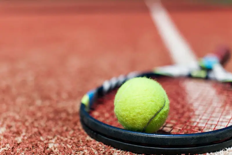 A tennis ball and racket on the court.