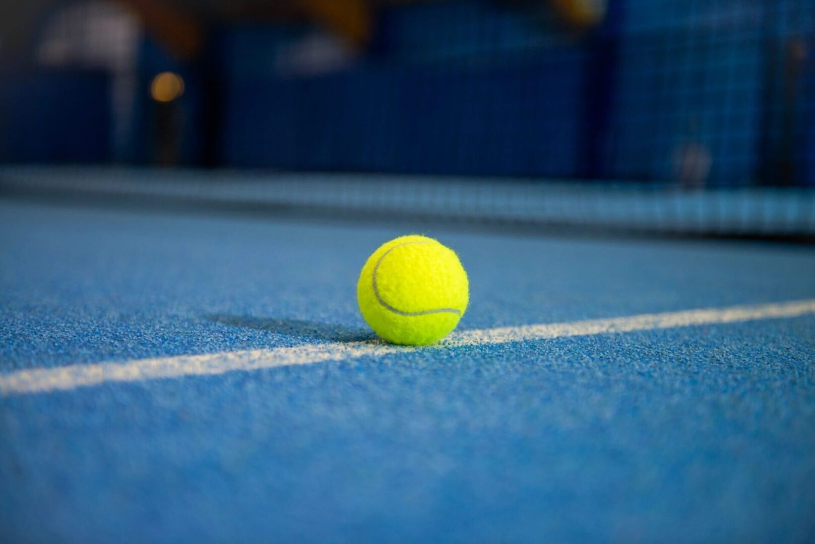 A tennis ball is sitting on the court.
